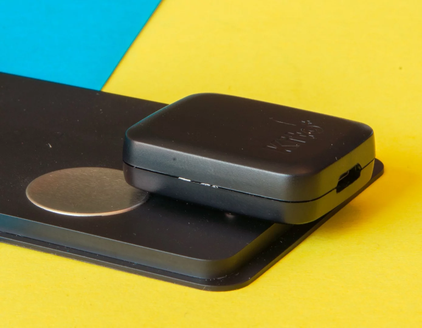 The Kito+ health tracker with the magnetic charger attached