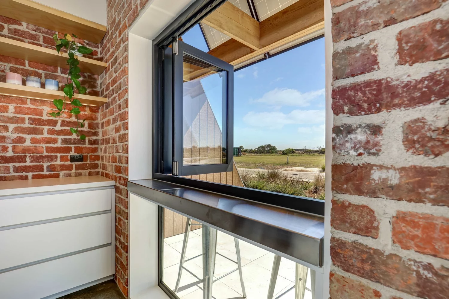 The kitchen window also doubles as bar top, with stools for sitting indoors or out