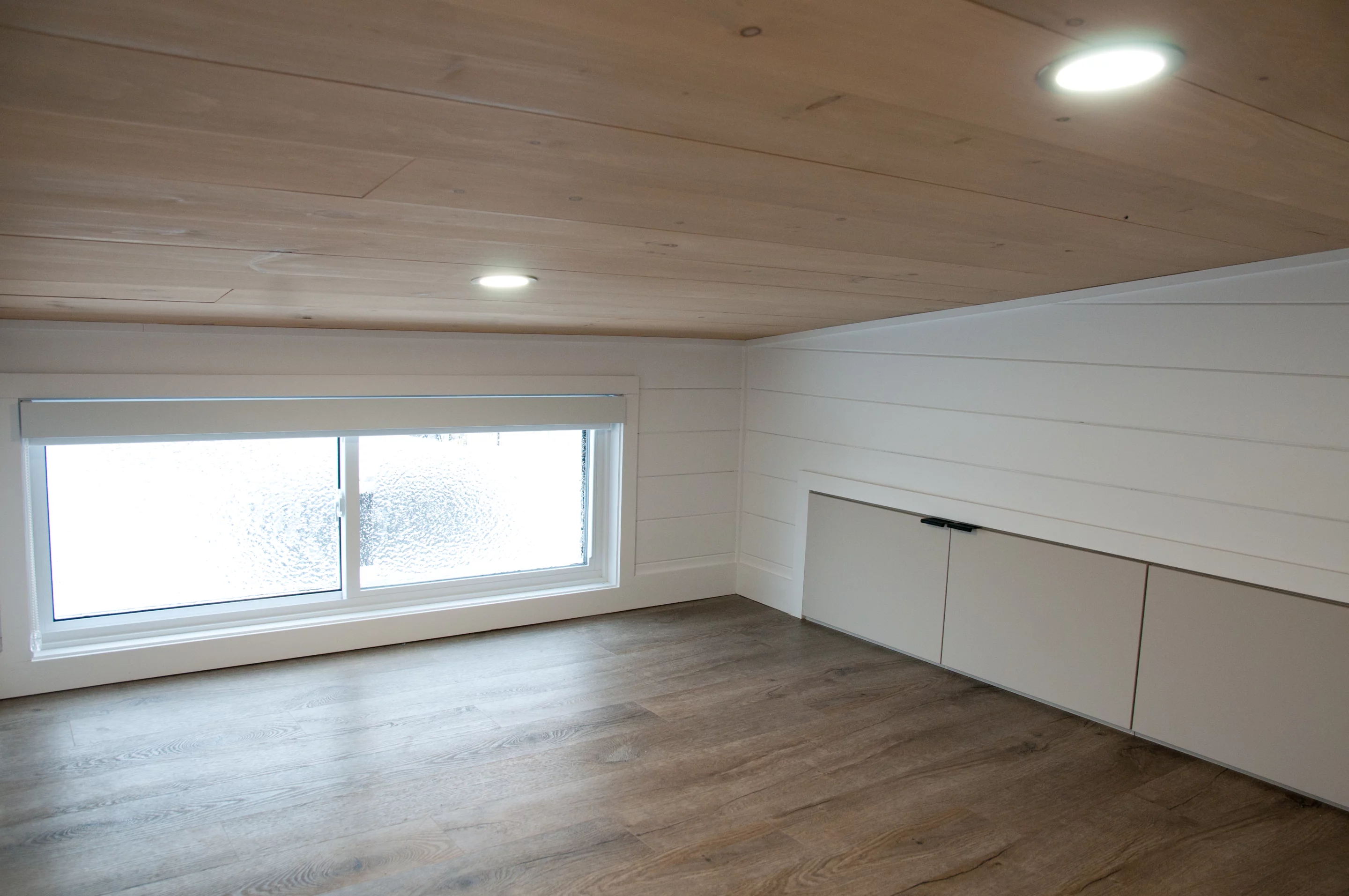 The Charme's loft bedrooms are typical tiny house-style bedrooms with a low ceiling