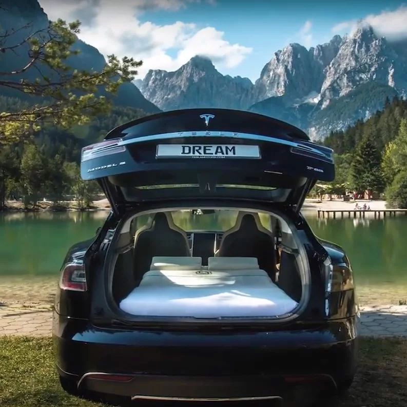 The Dreamcase Tesla Model S camper enjoys an idyllic, mountain-ringed lakeside camping spot