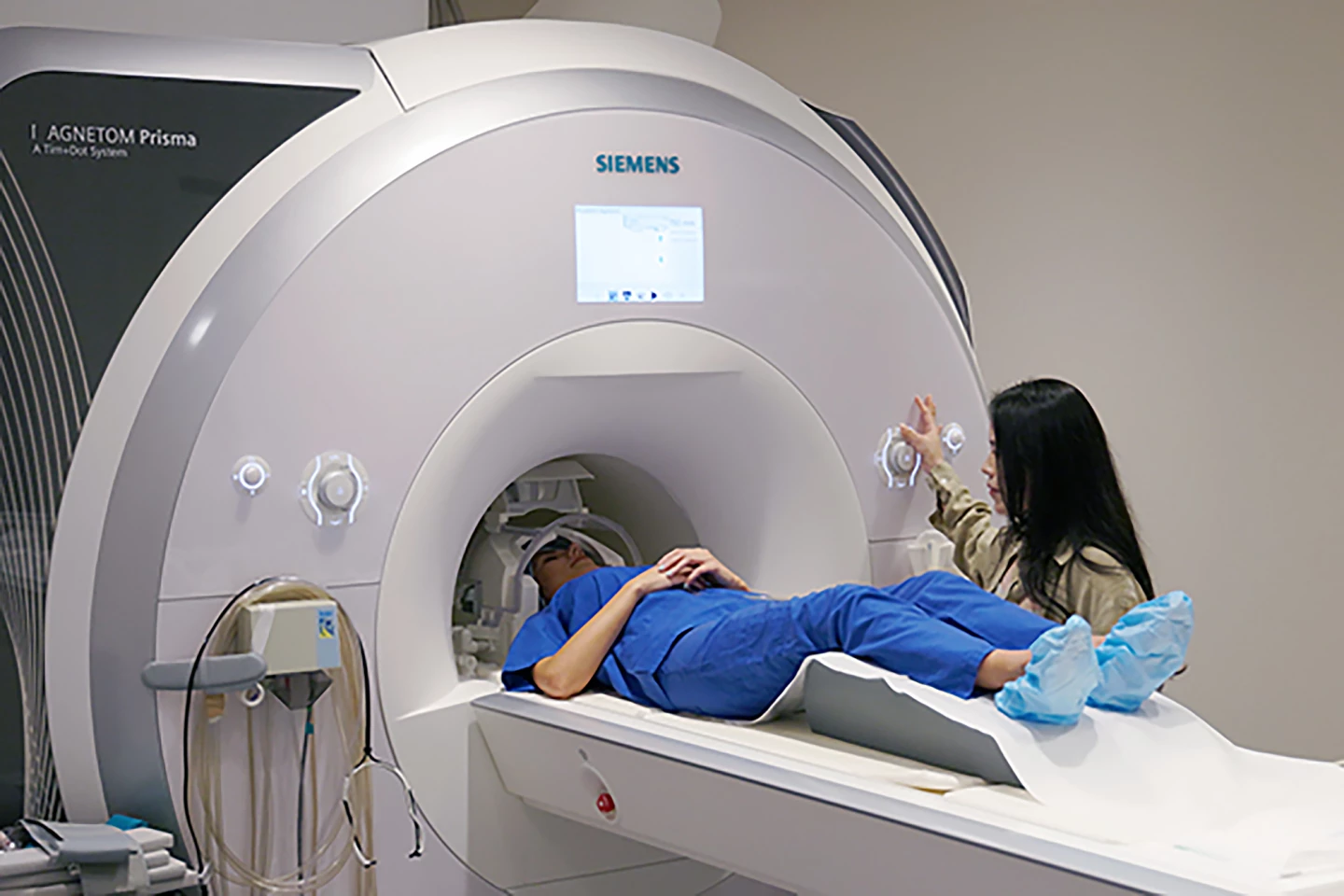 Yiren Ren readies one of her study participants for an MRI scan