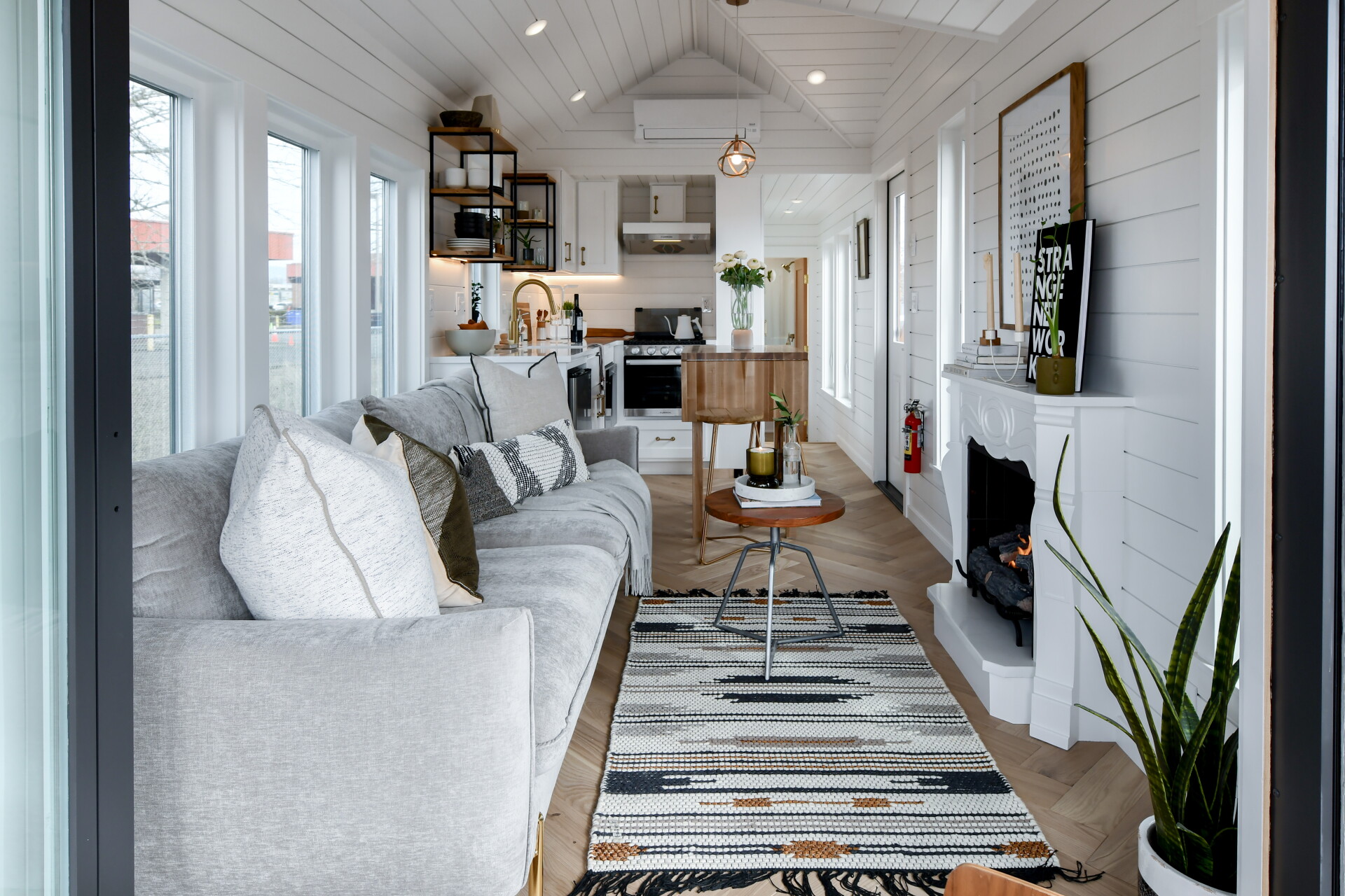 Tiny house boosts living space with motorized deck and spiral staircase