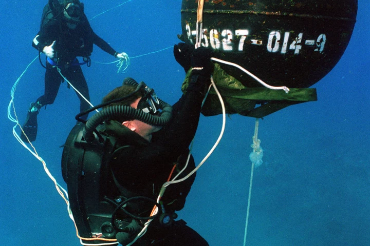 US Navy divers with a practice mine