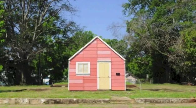 The Open House looks like a simple wooden home, but features separate sections that fold open to create a unique outdoor space