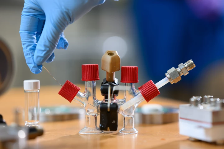 A proof-of-concept "H-cell" with a liquid sodium metal chamber on the left, an air chamber on the right, and a solid ceramic electrolyte (black) in the middle