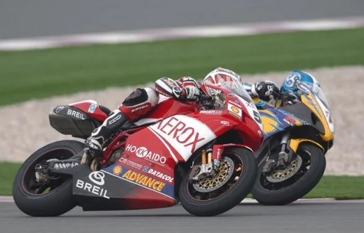 Regis Laconi's Ducati 999 and Yukio Kagayama's GSXR1000 exit a turn side by side at Losail.