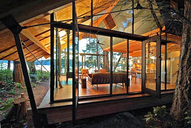A view of the glassed-in great room of Sneeoosh Cabin, looking through the cabin to the placid waters of Puget Sound (Photo: Zeroplus Architects)