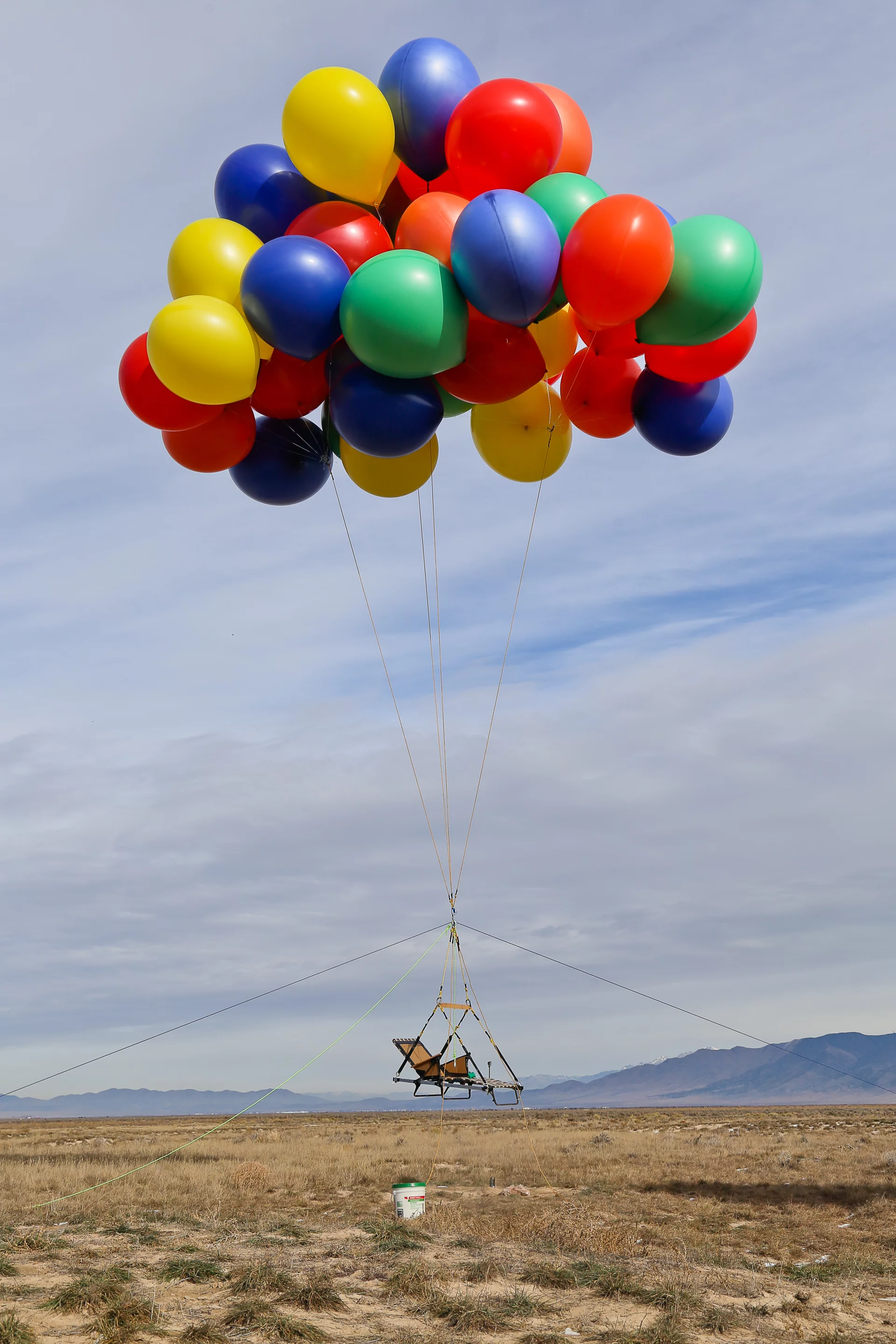 The sun lounger anchored to the ground with a group of balloons attached