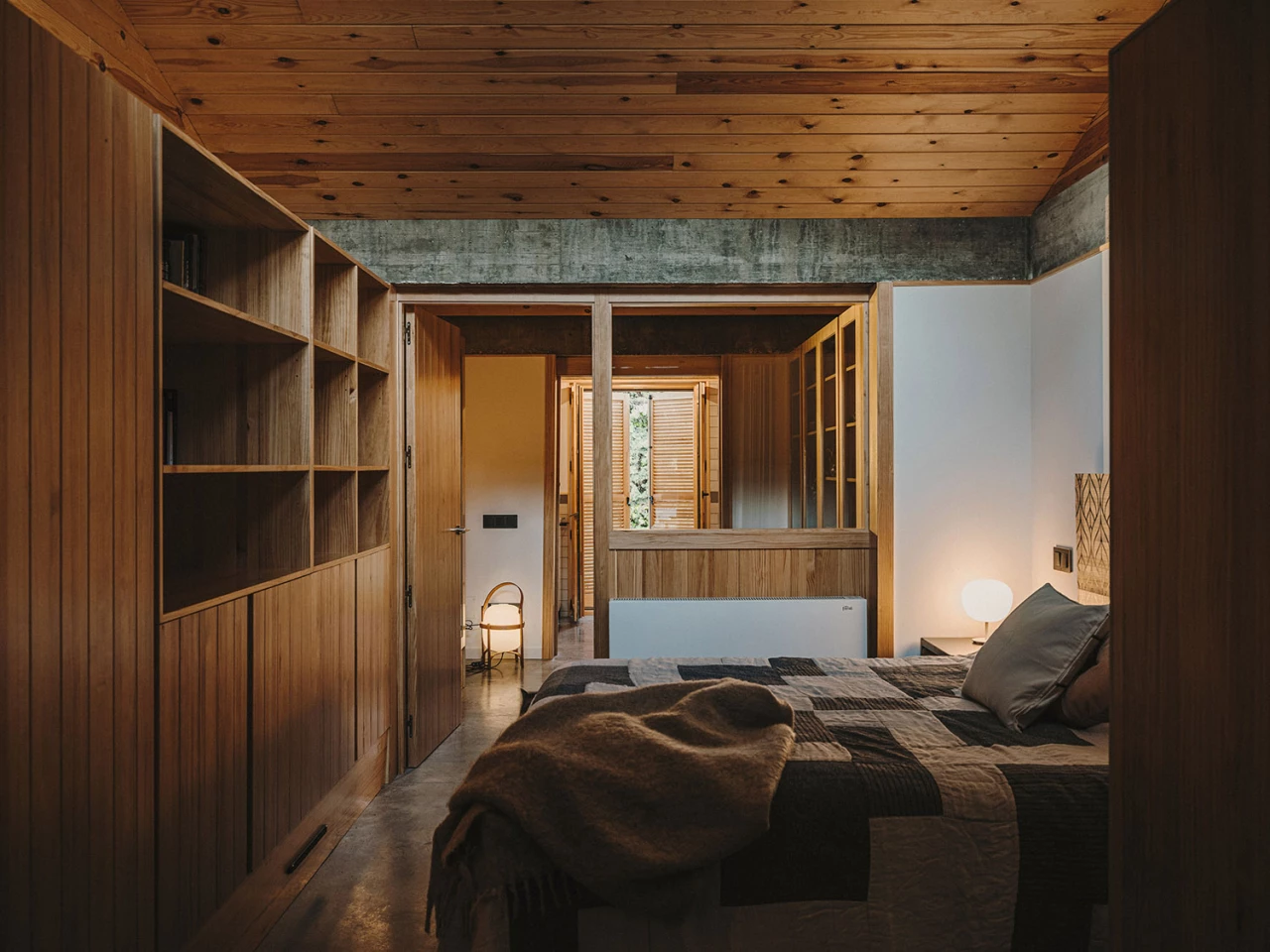 The double bedroom is filled with timber furnishings and natural light