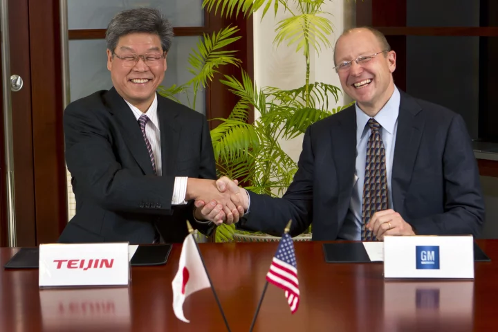 Teijin Senior Managing Director Norio Kamei (left) and GM Vice Chairman Steve Girsky shake hands after signing the carbon fiber deal (Photo by Jeffrey Sauger for General Motors)