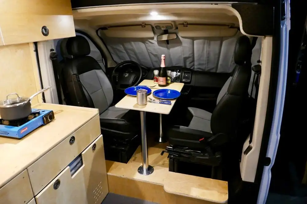 Glampervan's dining layout is a little different than other campers, putting the removable table right between the swivel cab seats