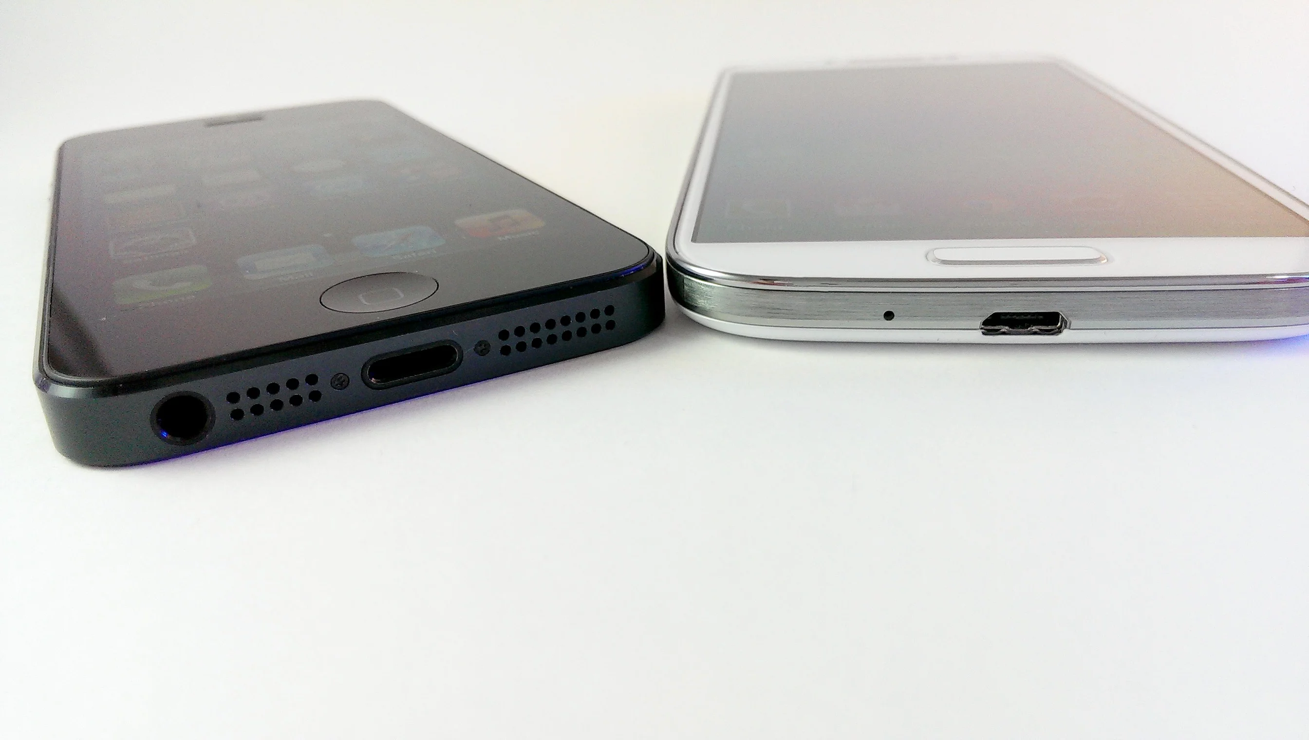 The iPhone 5 uses a proprietary Apple Lightning connector, while the GS4 uses a microUSB cable
