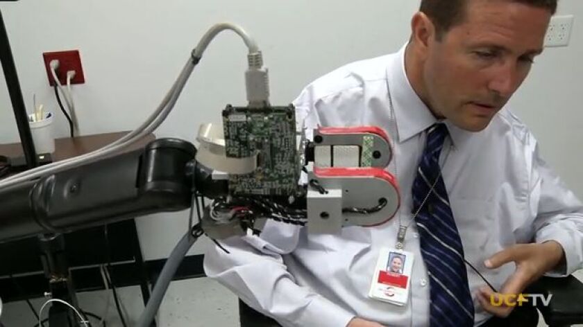Test subject Bob Melia tries out the UCF robotic arm
