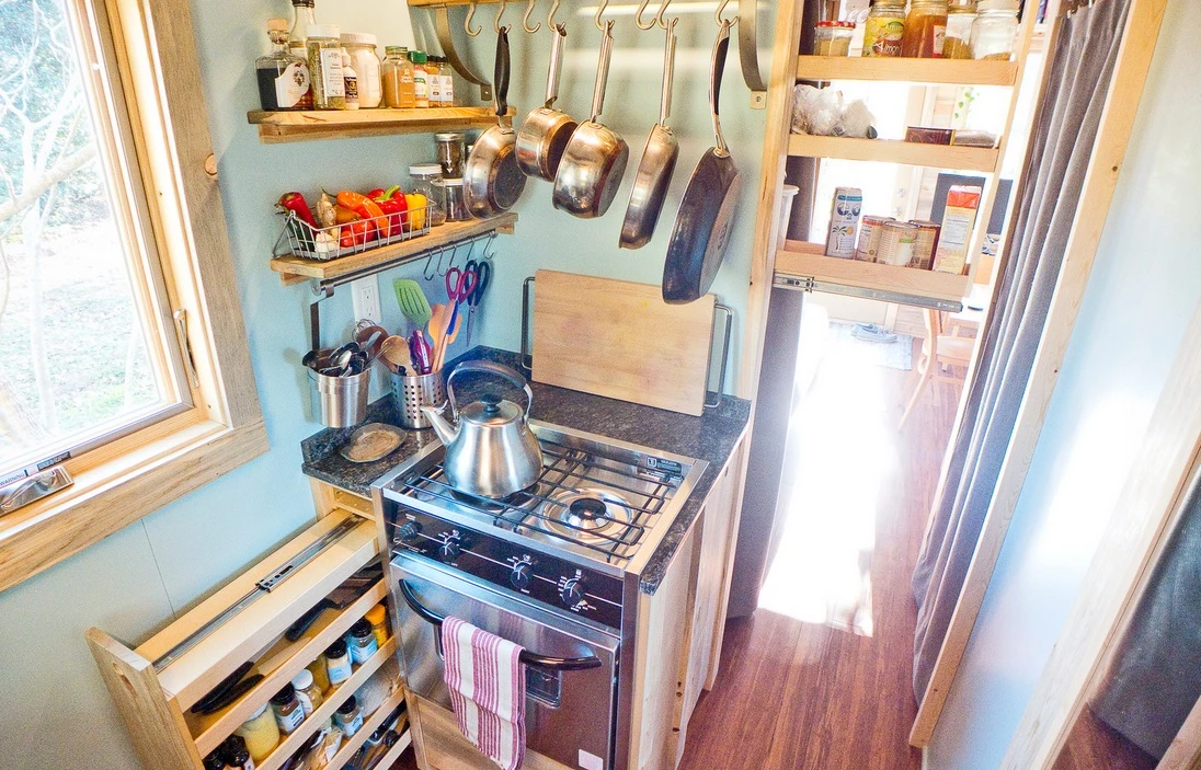 The kitchen features a two-burner stainless steel range stove with oven unit and a stainless steel counter-height fridge