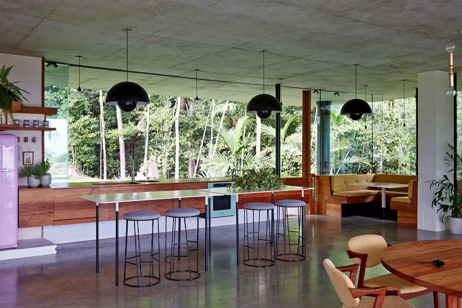 The Planchonella House uses the combination of greenery-covered roof, large sliding windows and concrete thermal mass to passively cool its interior