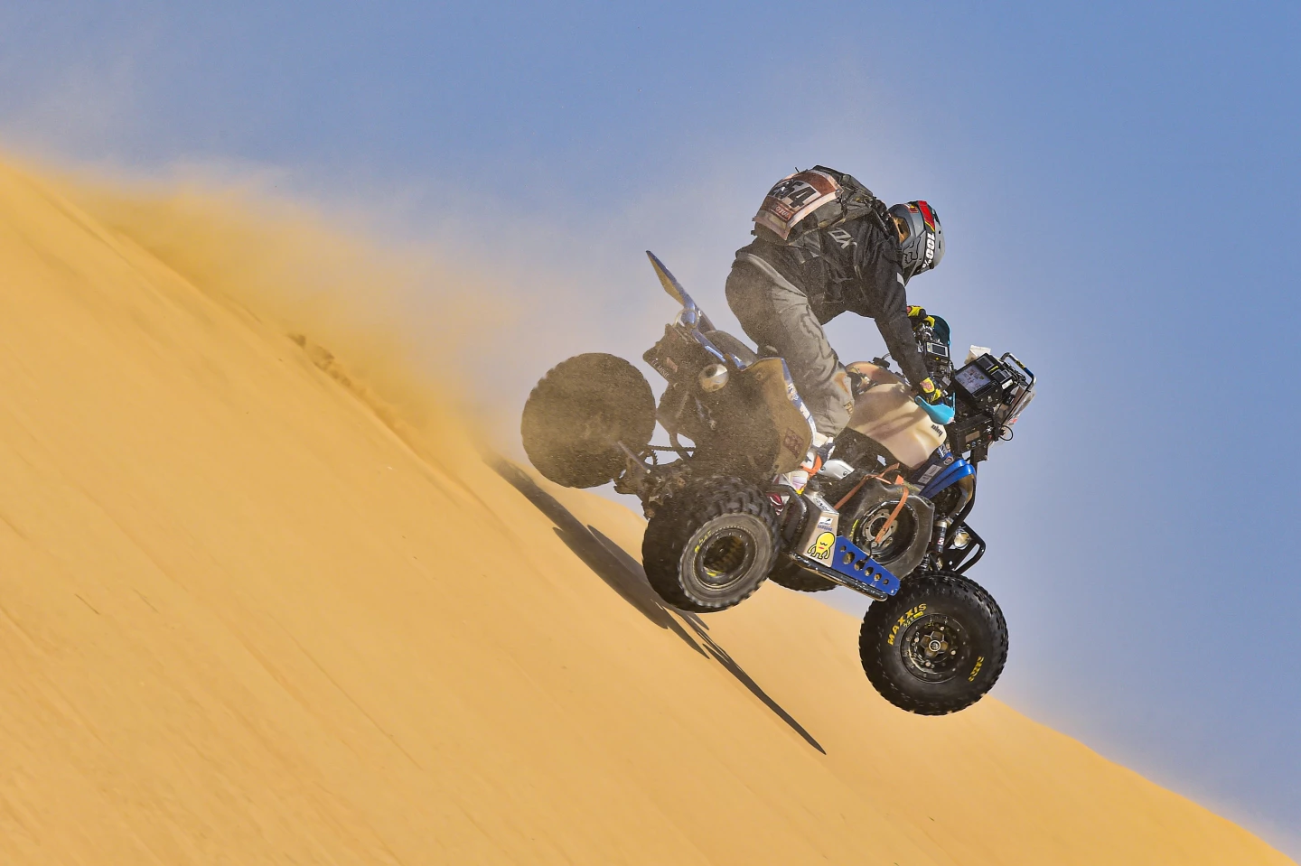 Neslon Augusto Sanabria Galeano flies down a dune on his Yamaha quad, carrying a fine spray of sand around him during stage 10