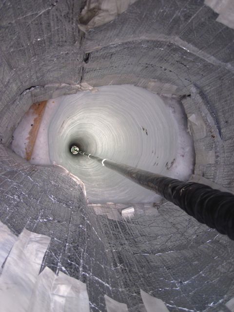 A sensor descends down a hole in the ice as part of the final season of IceCube