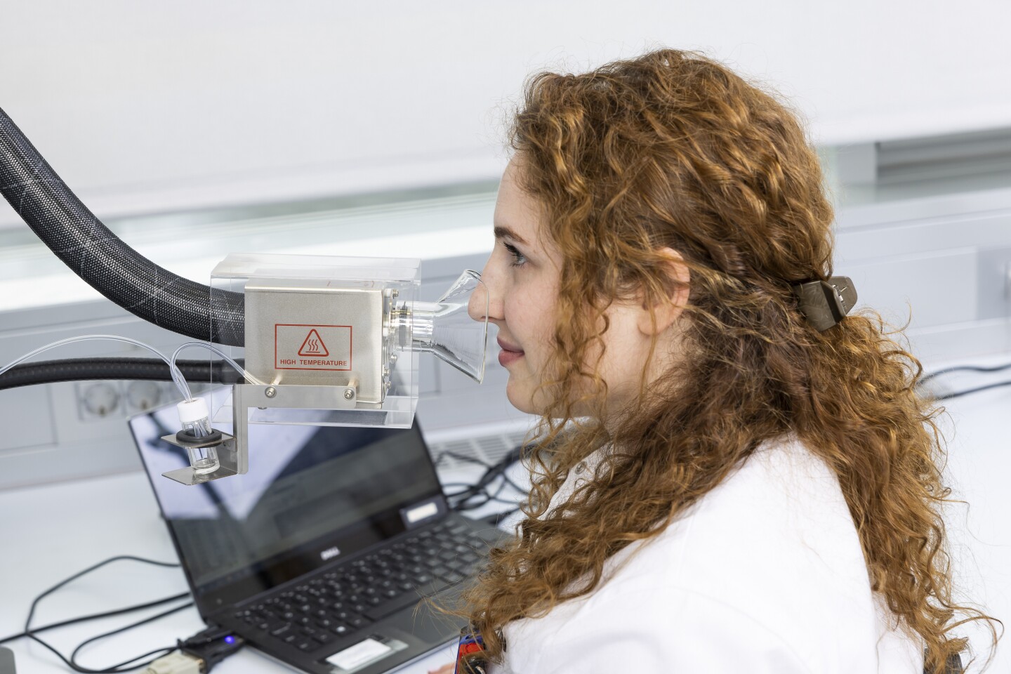 Researcher Emma Paolin smells a sample from an olfactory port of a gas chromatograph-mass spectrometer