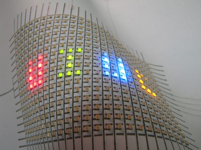 Hand-drawn silver ink lines form the interconnects between the flexible array of LEDs mounted on paper (Image: Bok Yeop Ahn)