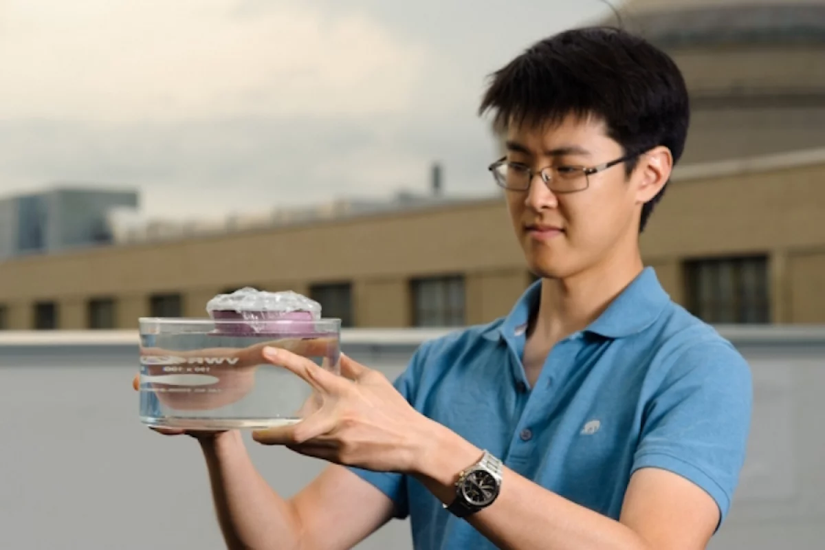 Graduate student and first author of the study George Ni holds the unique sponge-like device that can boil water through the absorption of sunlight