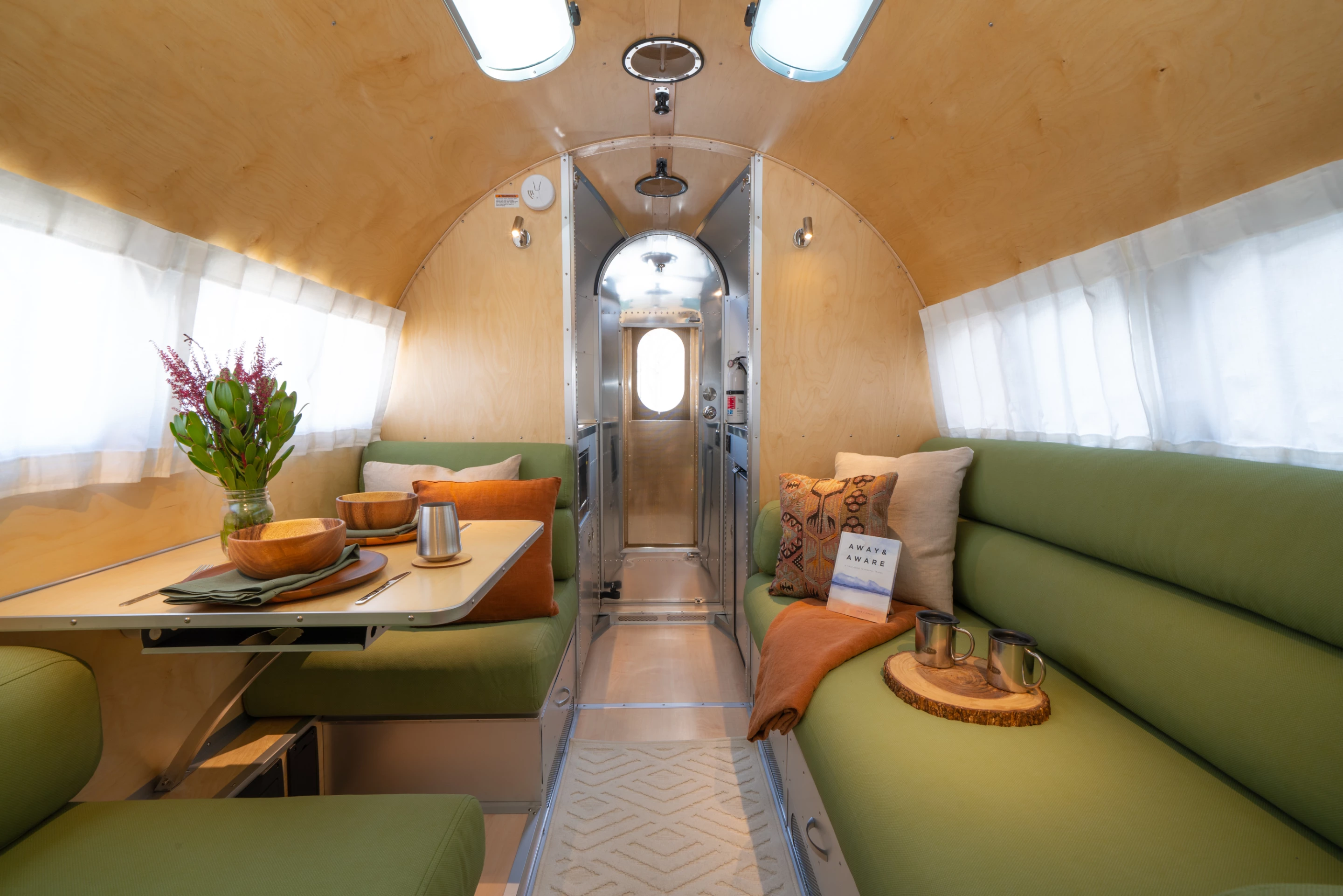 The dining area includes a two-seat booth and a sofa with removable table