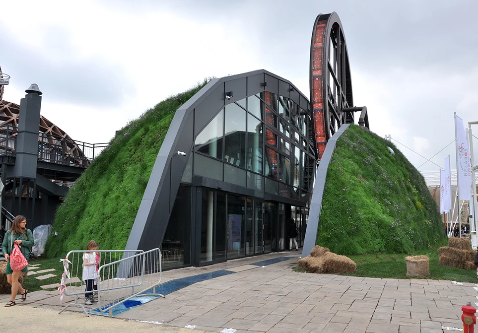 The Republic of Belarus Pavilion takes on the shape of a grassy knoll split into two