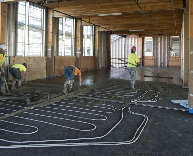 Concrete is poured over the building's underfloor hydronic system