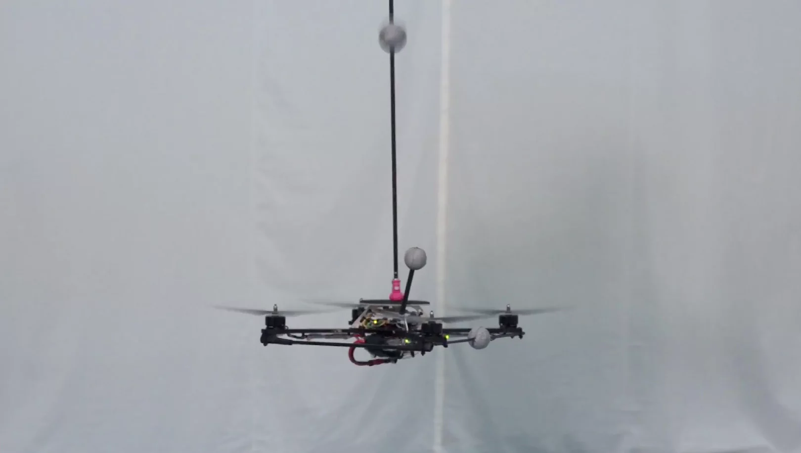 A quadrocopter moves perfectly into position, catching the falling pole precisely as it levels out
