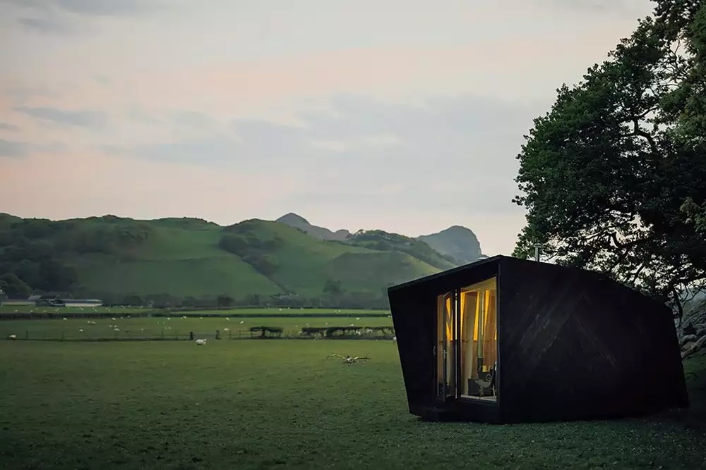 The exterior is clad with locally sourced black-stained Welsh wooden panels and sheep’s wool was used to insulate the cabin