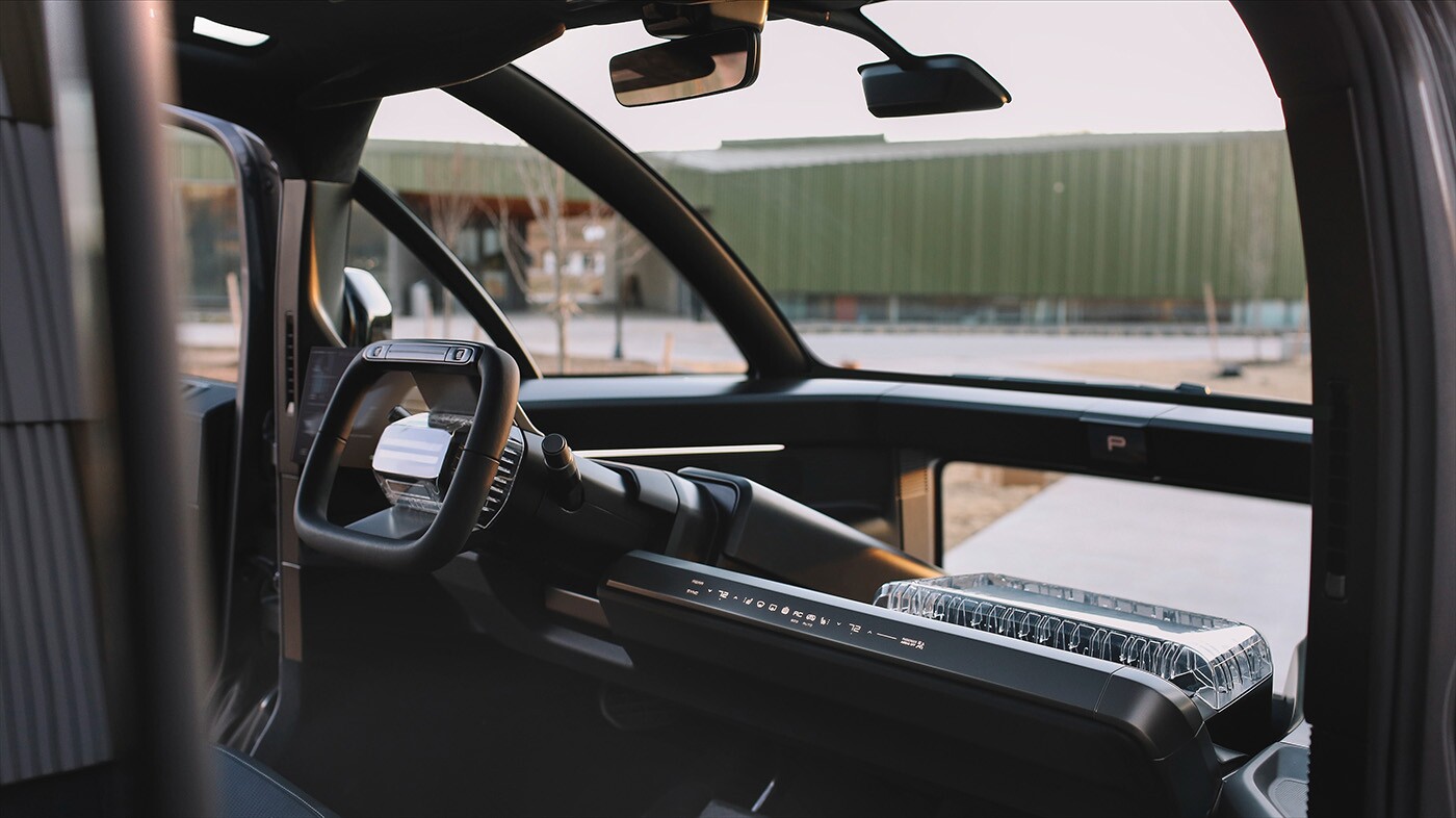 Canoo's unique interior includes an infotainment display to the driver's left, a steer-by-wire wheel for easier handling, and a 'Street View Window' for excellent visibility in front of the vehicle