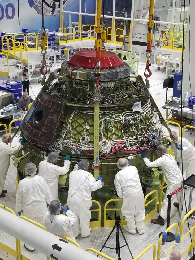 Boeing technicians lower the Starliner upper dome to the lower dome before bolting and sealing the pressure vessel