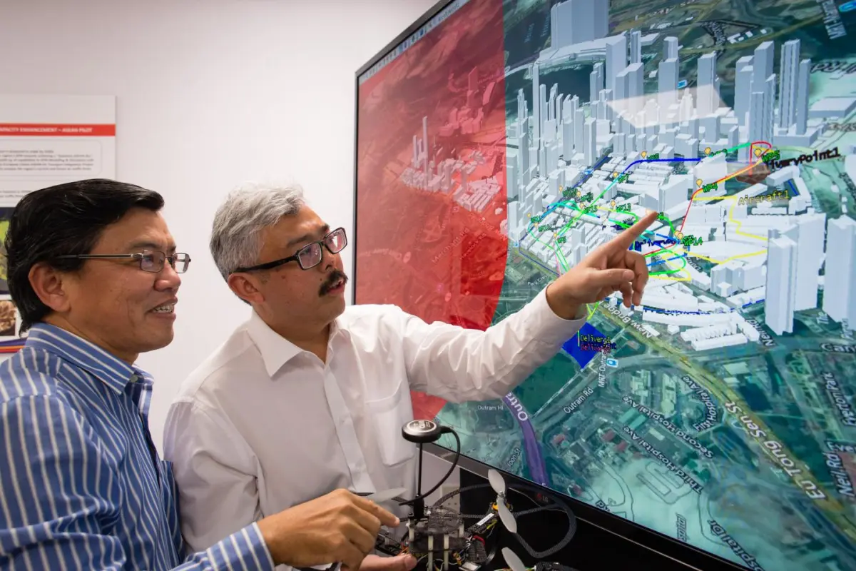 NTU Professor Low Kin Huat (left) and Air Traffic Management Research Institute's Deputy Director Mr Mohamed Faisal Bin Mohamed Salleh discussing an NTU-developed air traffic simulation, which takes into account various solutions to enable safe and efficient drone travel in Singapore.