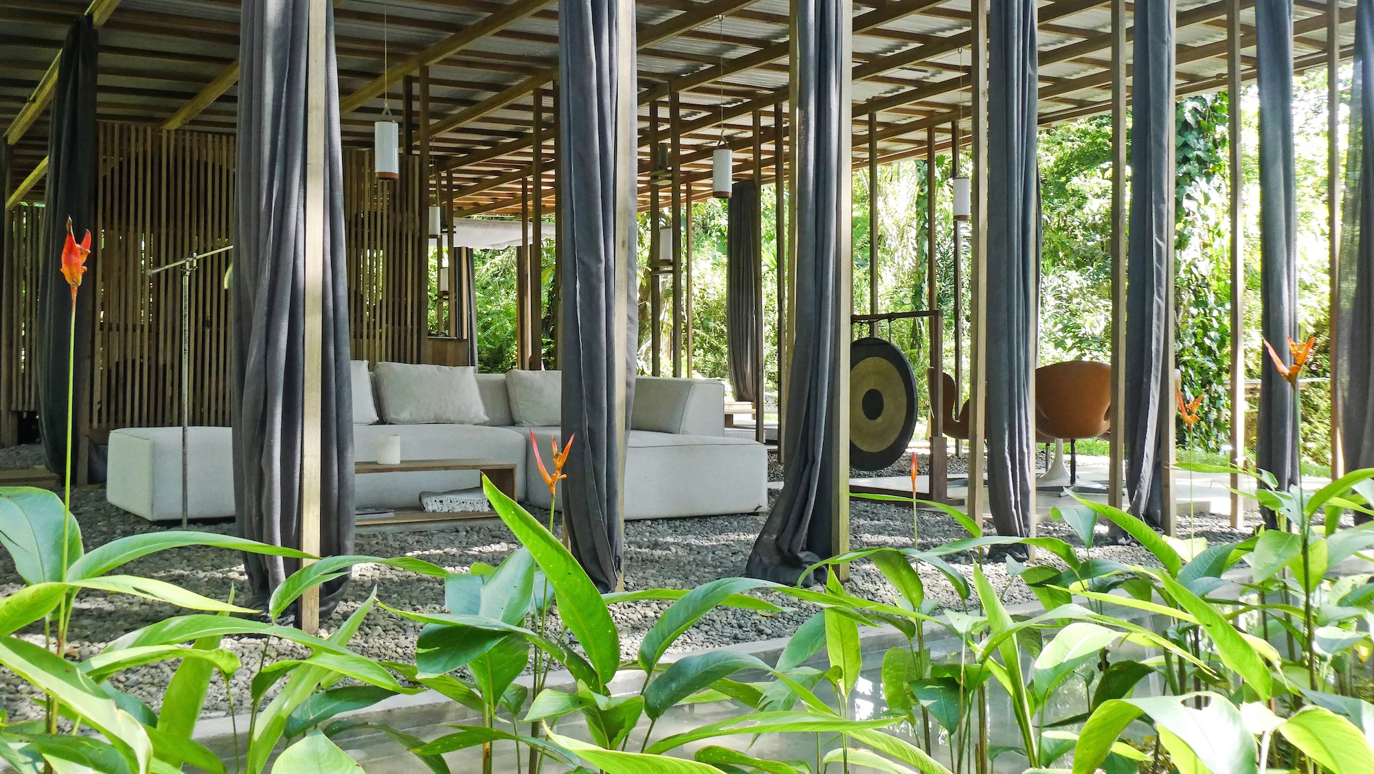 The Open Jungle House features a spacious living room area with a sofa and a small coffee table