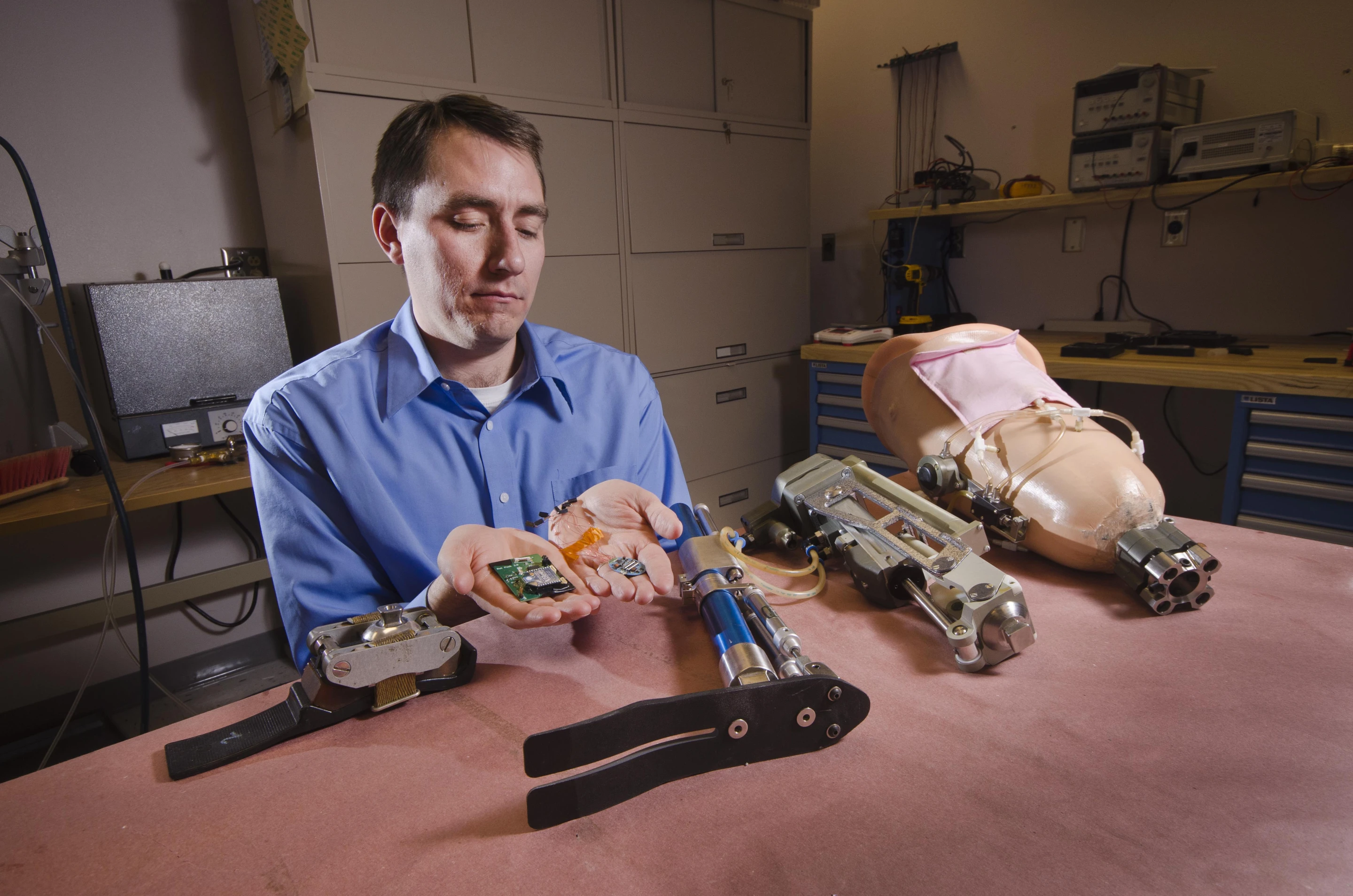 Robotics engineer Steve Buerger holding implantable neural interfaces being developed for artificial limbs (Image: Sandia Labs)