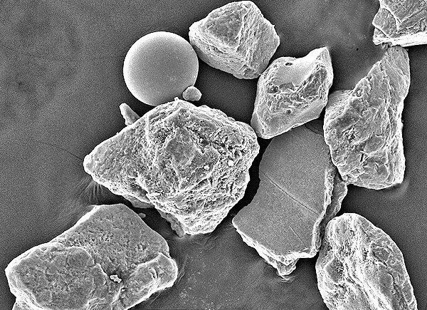 Scanning electron microscope image of shrapnel grains and an iron bead, remnants of the D-Day invasion. (Photo: Earle F. McBride/M. Dane Picard)
