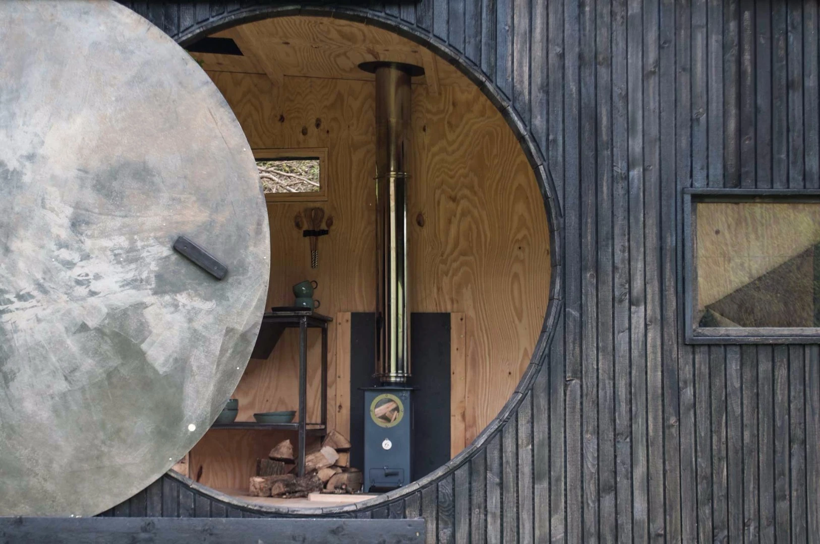 Animated Forest features a circular rolling door, which opens the dwelling up to the outdoors