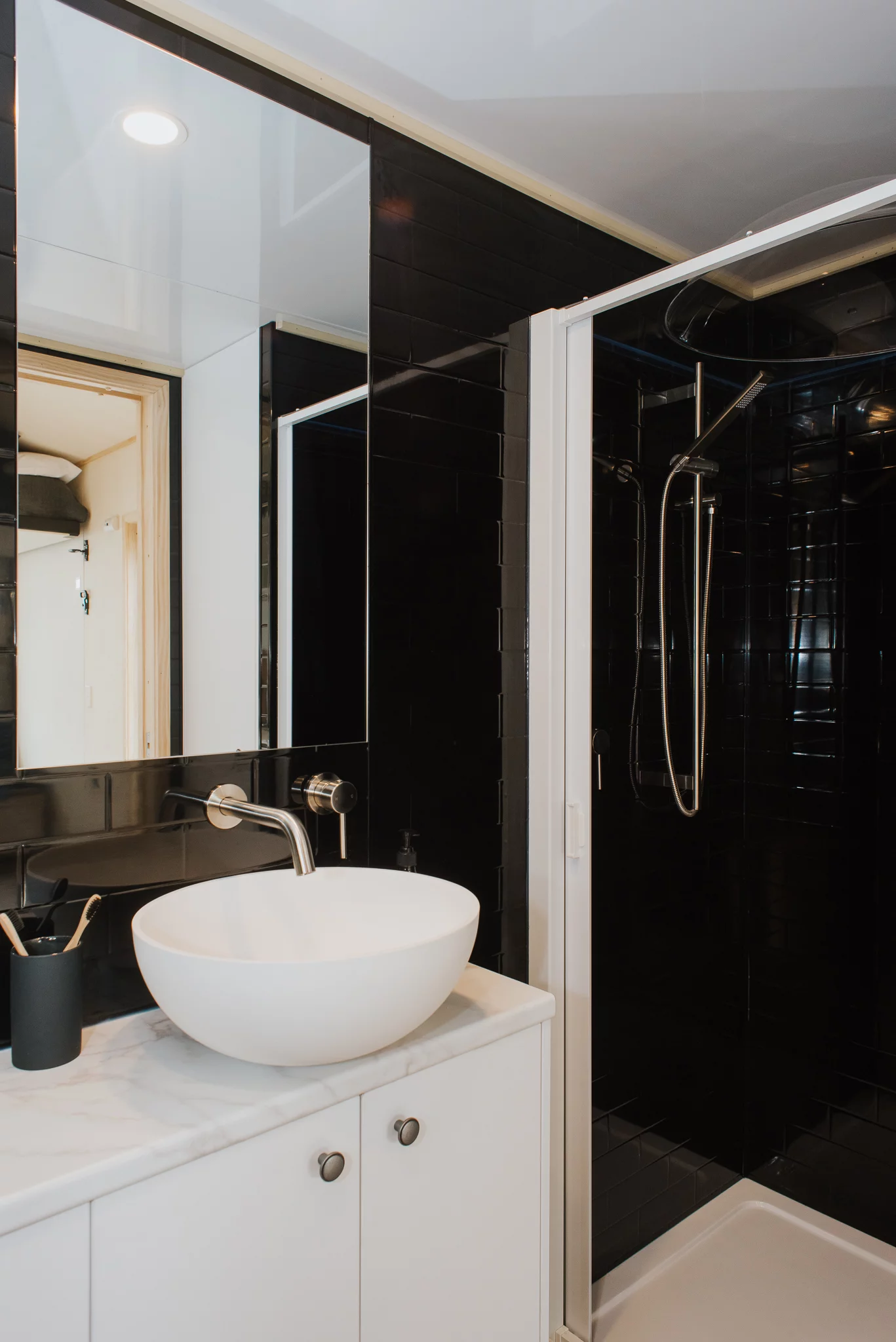 The Te Whare Nukunuku Tiny House's bathroom includes a sink, shower, and composting toilet