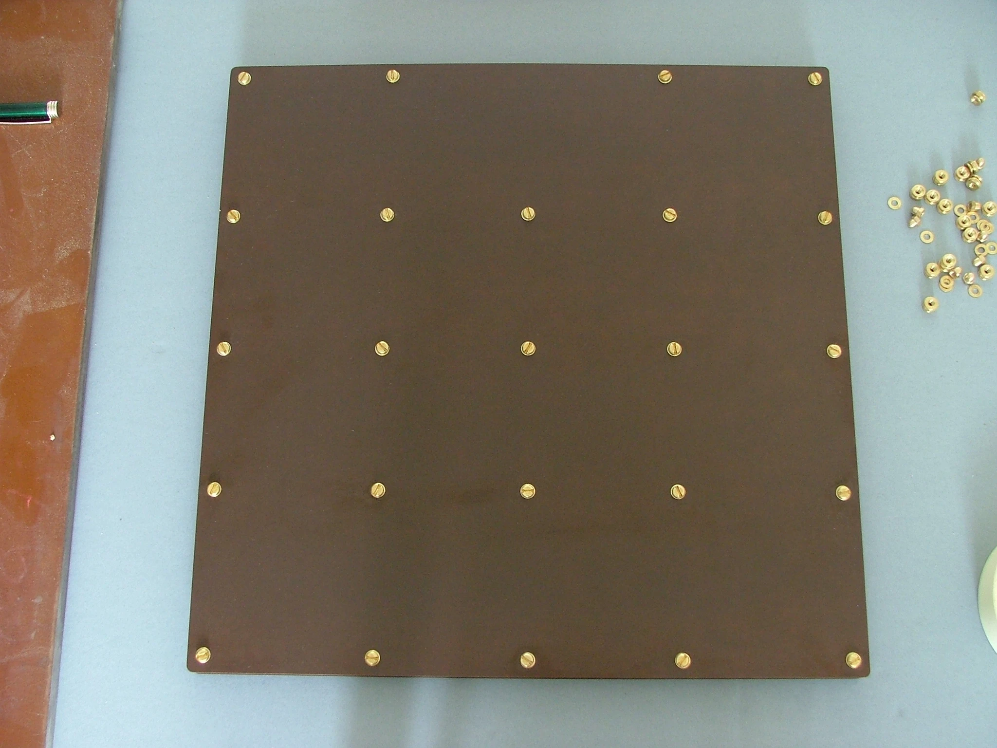 The bottom of the NOS Tufnol and phenolic resin laminate case, showing the placement of brass bolts