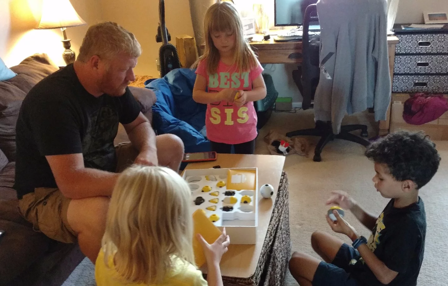 Here the author is receiving instruction on the Mabot from his 8-year-old as the 6-year-old eyeballs one of the parts and the 7-year-old opens a box of connectors