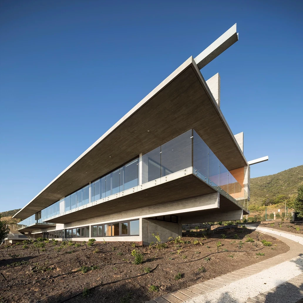 La Casa H is built into hills around the coastal town of Zapallar, leaning on a set of four monster reinforced concrete beams running the length of the structure