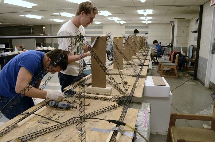 Team members Patrick Gunson and James Galatola assemble the micro-trusses into one of the four airframe truss arms