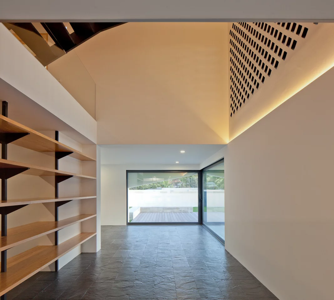 Downstairs, a part-perforated wall enables the breeze to permeate the interior when the covering window is opened (Photo: José Campos)