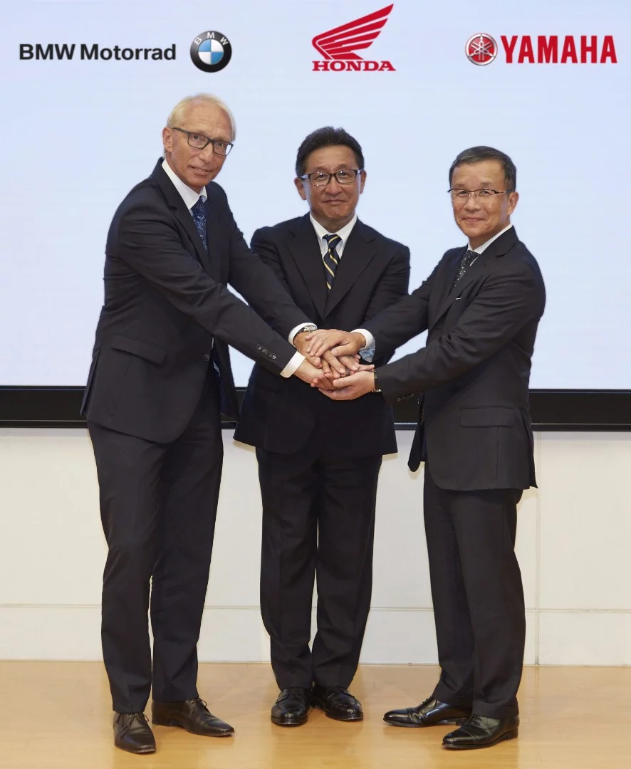 Representatives from the three companies shake on the new cooperation. From left to right: Prof. Dr. Karl Viktor Schaller, Executive Vice President Development BMW Motorrad, Mr. Tetsuo Suzuki, Operating Officer at Honda Motor Co., Ltd. and Mr. Takaaki Kimura, Chief General Manager of Technology Center and Executive Vice President and Representative Director of Yamaha Motor Co.Ltd.
