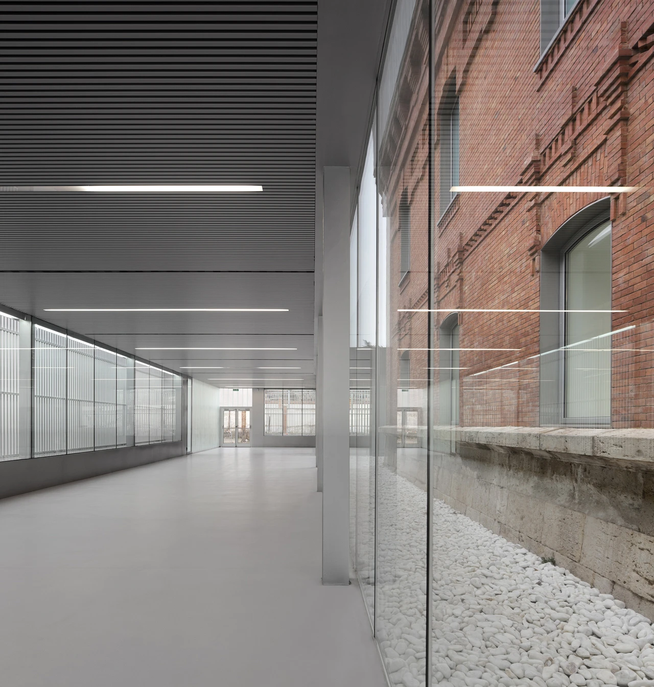 The four wings and central hall of the old prison are connected by new pavilions of the same zinc and translucent construction
