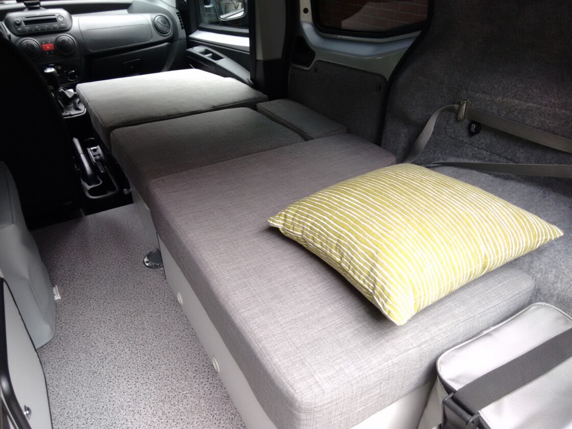 Fold the passenger seat, drop the tabletop in place, put the cushions on and you have a single bed