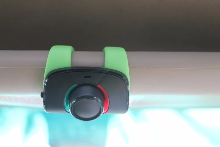 The Parrot Minikit Neo 2 HD perches on a windshield visor, ready to respond to voice commands and make phone calls in HD sound