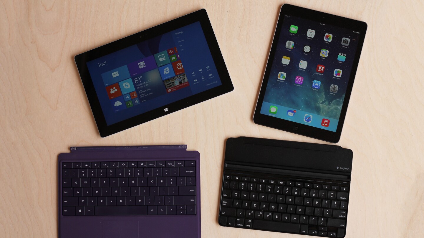 The Surface Pro 2 (with Power Cover) and iPad Air (with Logitech Ultrathin Keyboard Cover)