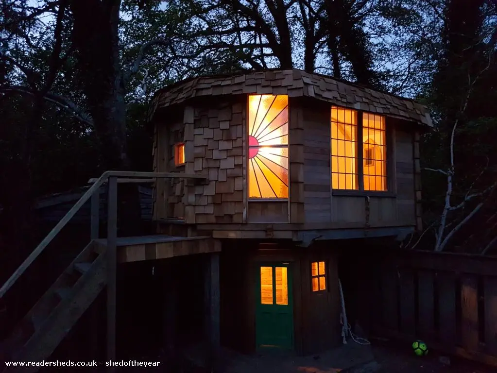 The Mushroom House lit up at night