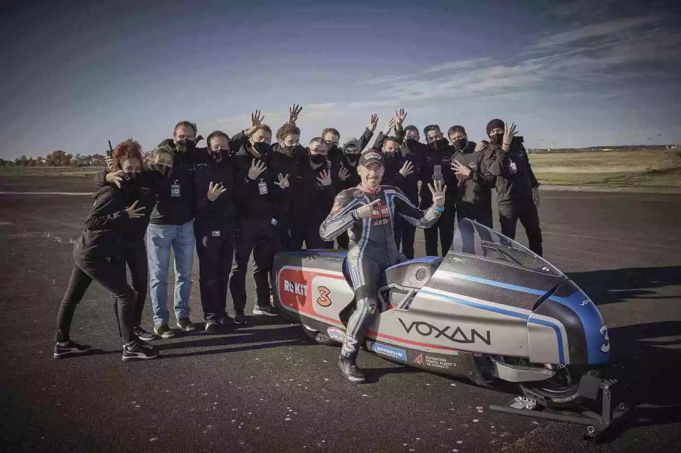 Biaggi and the team hold up four fingers to celebrate hitting a top speed over 400 km/h (250 mph)