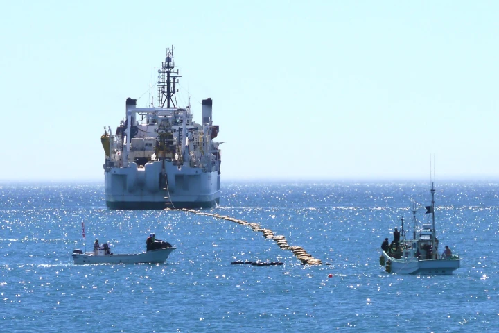 The brown bag-like objects are floats that hold the cable up so it doesn't drag on the ocean floor – they are removed after the cable is run